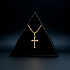 Collar Cruz Cristo en oro sólido 10K presentado sobre exhibidor negro.